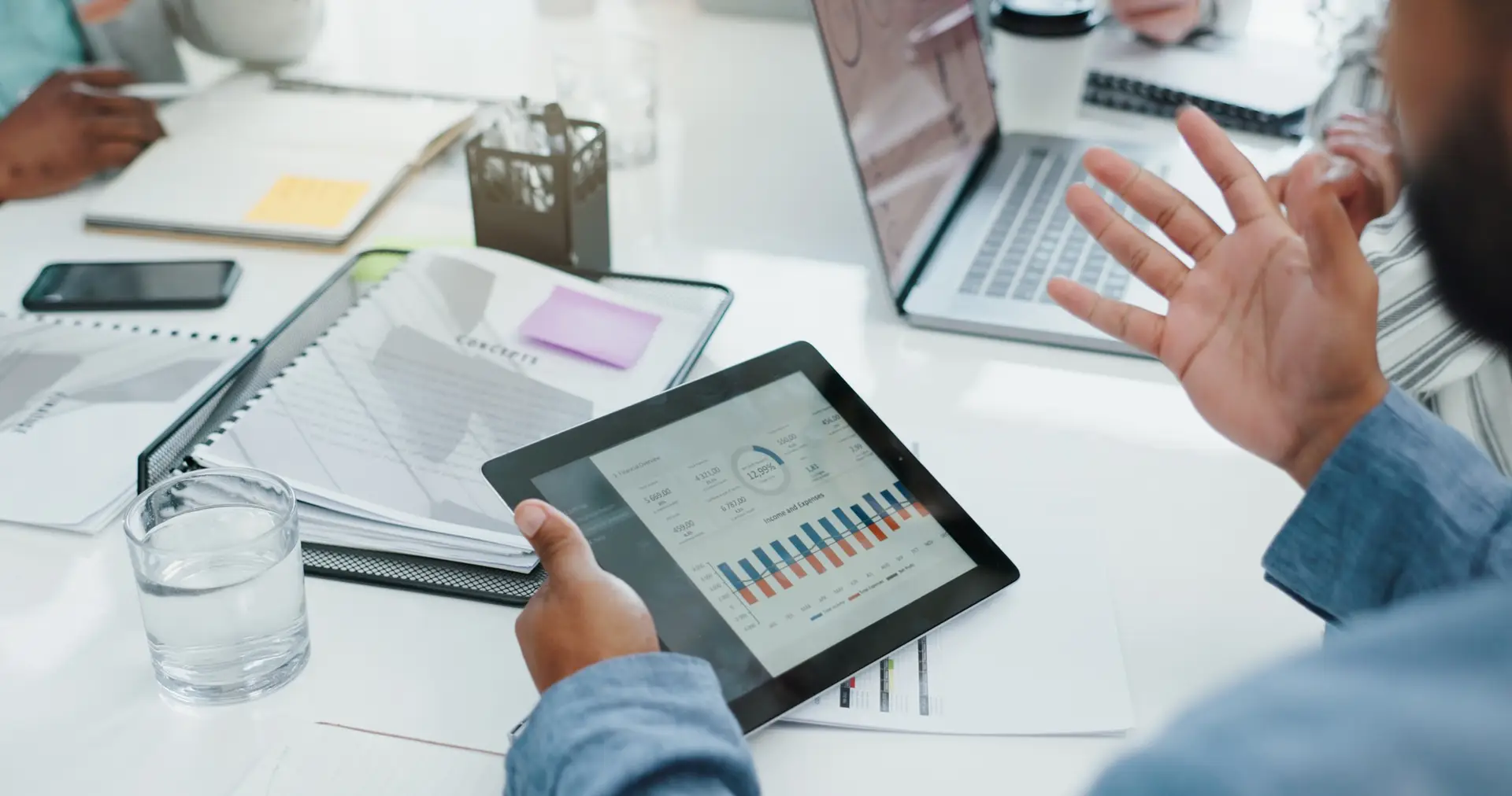 Above, hands and business people with tablet screen for graphs, charts and feedback of performance.