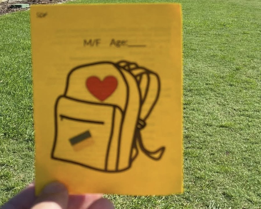 A yellow intake card printed with a backpack and heart illustration