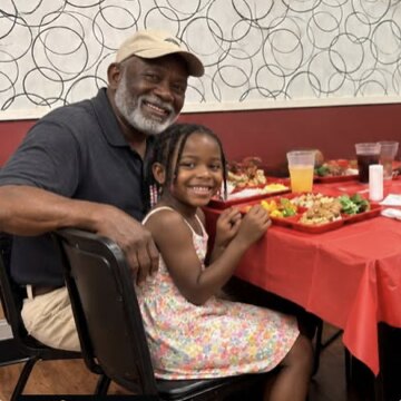 A man and a young girl sharing a meal in the Hosea House dining room