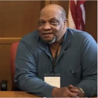 Portrait of a man seated at a conference table